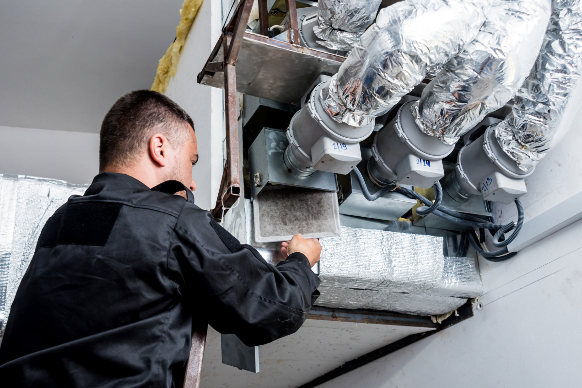 An HVAC technician performing some Kennesaw HVAC Services.