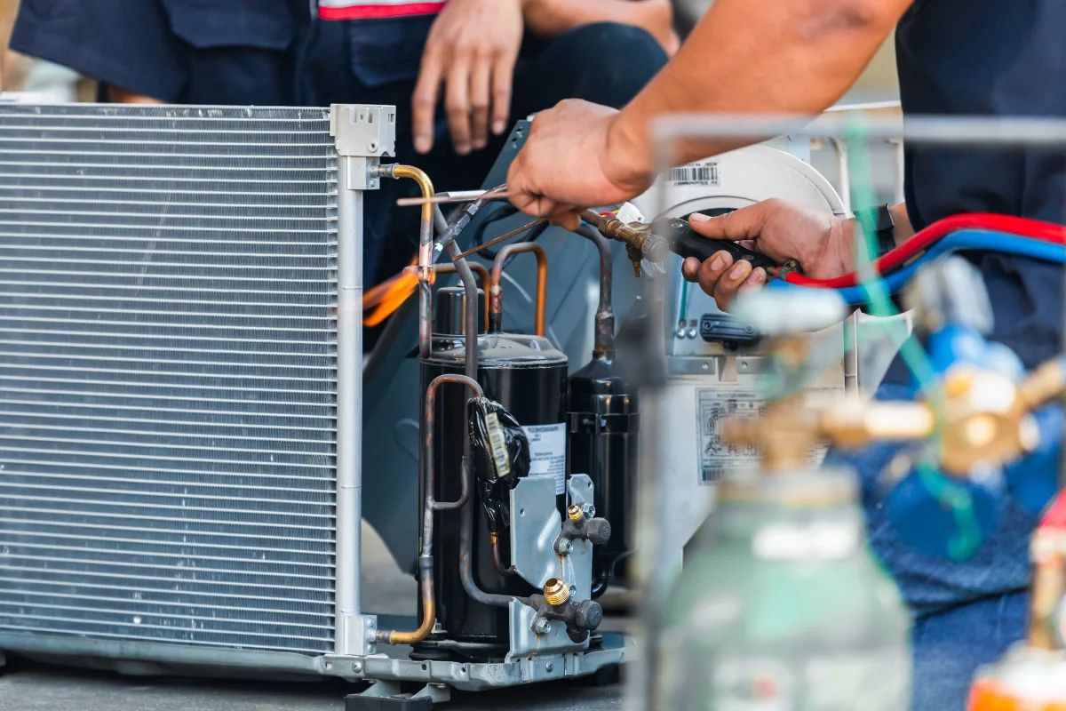 Atlanta HVAC Company - Commercial HVAC Services A Norcross HVAC Services specialist fixing an air conditioning unit.