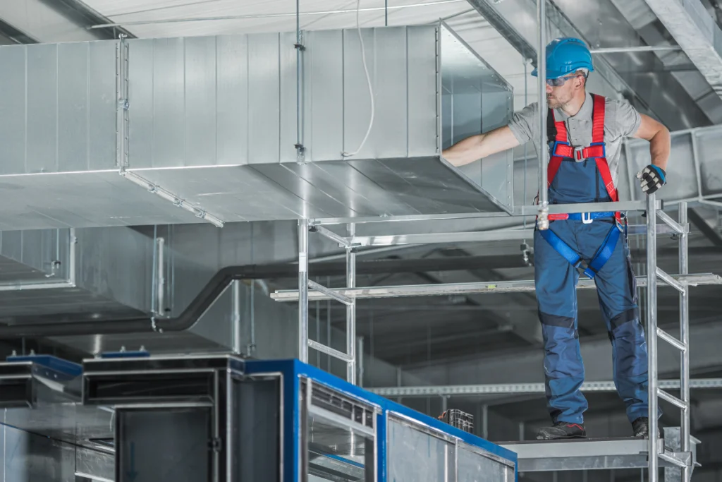 HVAC In Sustainable Building Design: Efficiency For Commercial Buildings 1 An HVAC maintenance done by a professional in a building with sustainable building design.