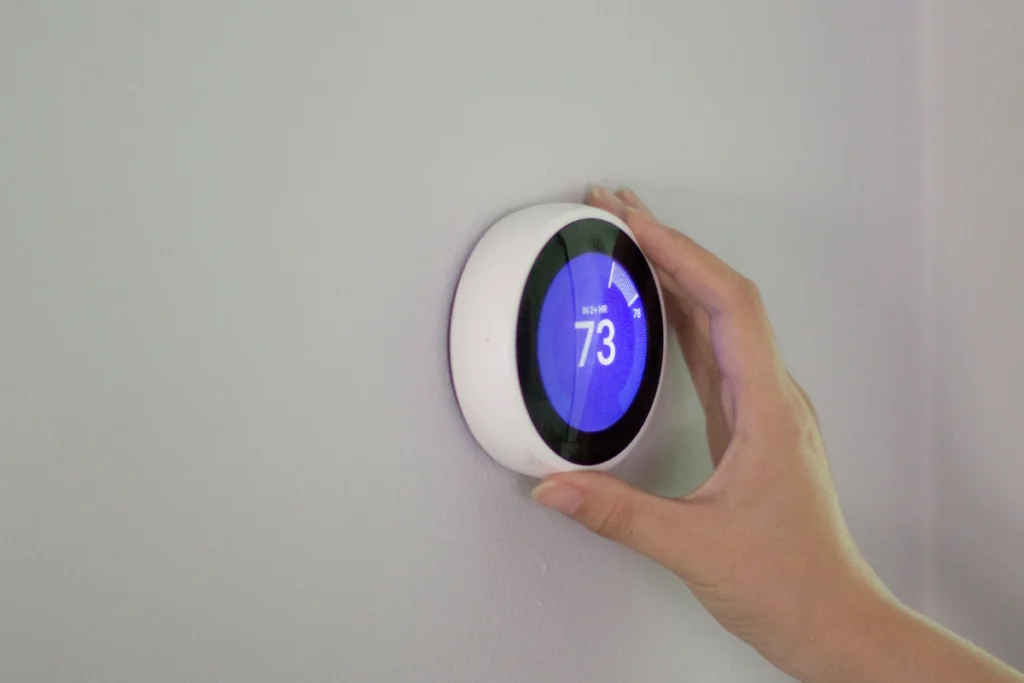 HVAC In Sustainable Building Design: Efficiency For Commercial Buildings 2 A hand adjusting a digital thermostat.